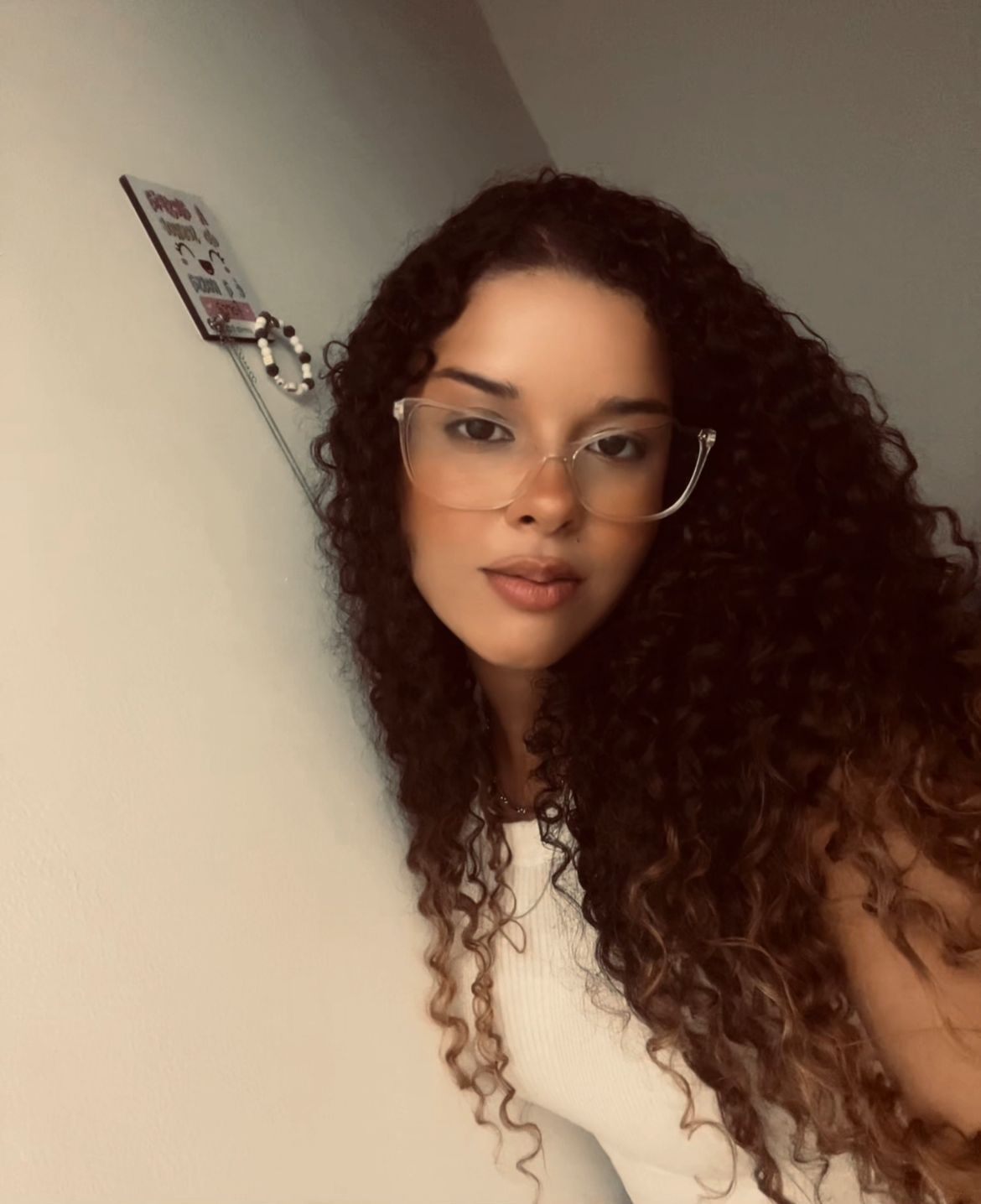 Imagem da Desenvolvedora Bruna, de óculos e blusa branca